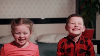 girl playing with guy in black and red plaid shirt, making grimaces