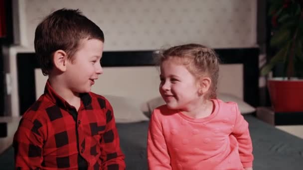 Chica juega con chico, hermana unta a sus hermanos cara con pastel — Vídeo de stock