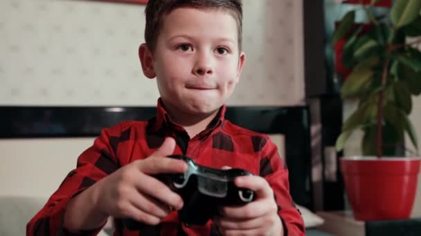Niedlicher Junge spielt Videospiel, hält Steuerknüppel, hat eine emotionale Zeit — Stockvideo