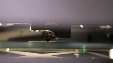 3D technology close up of the printer head printing a plastic part product.