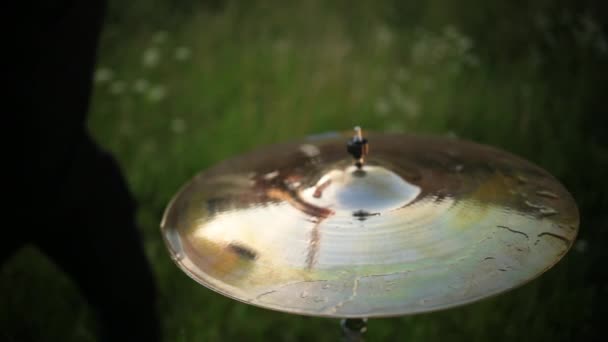 Барабанщик стучит по мокрым барабанам, и вода брызгает в замедленной съемке — стоковое видео