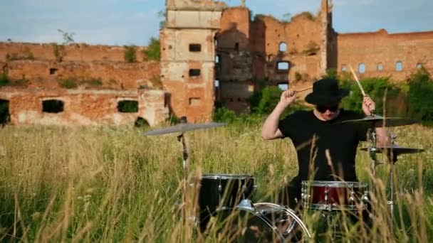 Muzikant drummer gekleed in zwarte kleren, hoed, het spelen van de drum set en bekkens — Stockvideo