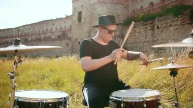siyah şapka giymiş müzisyen davulcu, davul seti ve ziller, sokakta oynuyor