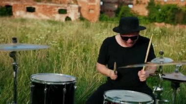 siyah şapka giymiş müzisyen davulcu, davul seti ve ziller, sokakta oynuyor