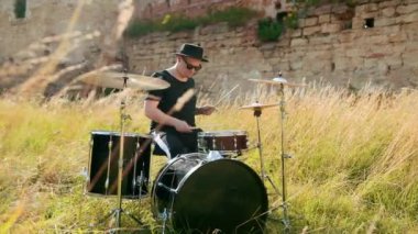 siyah şapka giymiş müzisyen davulcu, davul seti ve ziller, sokakta oynuyor