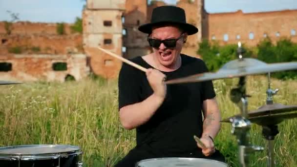 Baterista músico vestido com roupas pretas, chapéu, tocando bateria e pratos — Vídeo de Stock