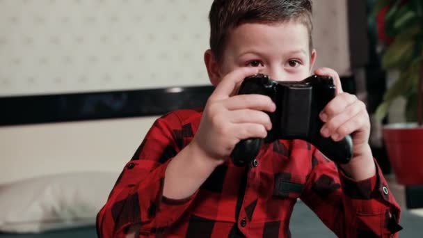 Schattig jongen spelen video game, holding joystick, met een emotionele tijd — Stockvideo