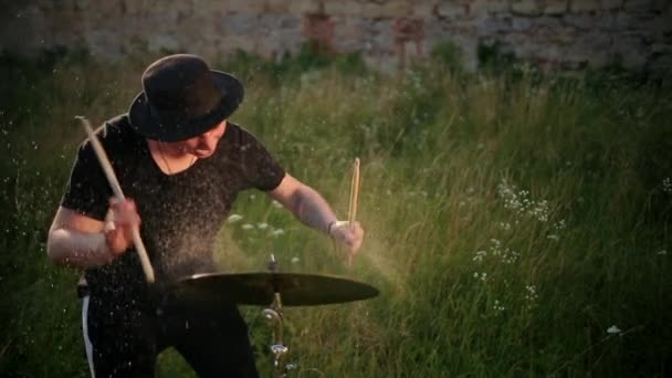 Drummer muzikant slaan op natte trommel bekken en water spatten in slow motion — Stockvideo