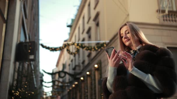 Mujer rubia joven marca el número de teléfono y habla alegremente — Vídeos de Stock