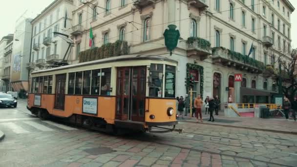 Um velho eléctrico laranja atravessa uma cidade europeia em Itália. quaisquer casas bonitas — Vídeo de Stock