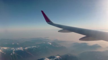 İsviçre Alpleri 'nin güzel manzarasının üzerinde uçan bir uçağın kanadı..