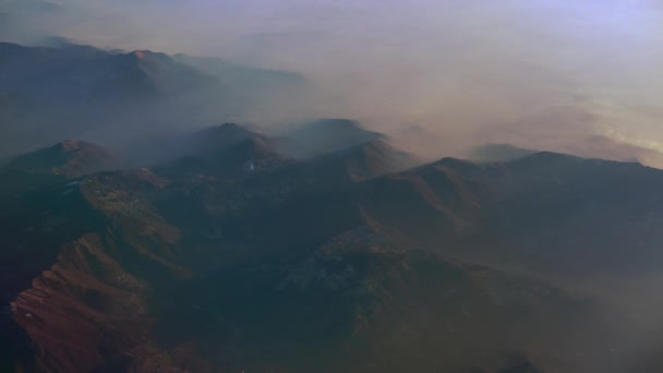 Vista a volo d'uccello sulle Alpi. Picchi innevati e nebbia mattutina . — Video Stock