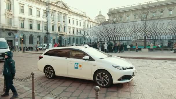 Vit taxi kör gatan. Ljus solig dag, folk väntar på transport — Stockvideo