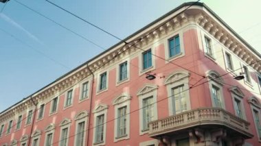 Açık turuncu renkli, balkonlu, güzel mavi gökyüzü olan bir İtalyan evi.