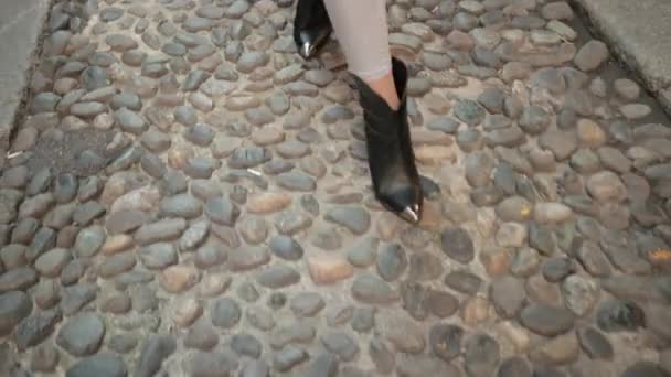 Vrouwen zwarte schoenen gaan op bestrating, niet gelijk aan stenen die deel uitmaken van de weg . — Stockvideo