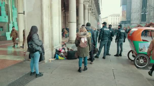 Безпритульний чоловік у Санта - Клаус - Капелюх лежатиме на вулиці, в оточенні поліцейських — стокове відео