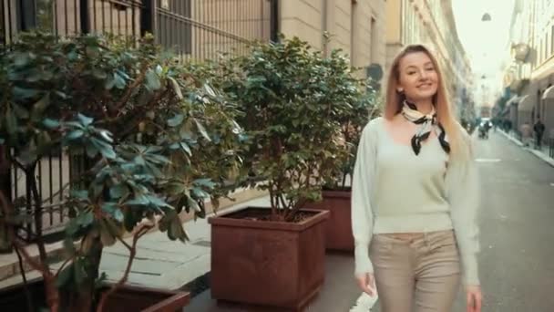 Młoda blondynka przechodzi przez starożytne włoskie miasto Mediolan — Wideo stockowe