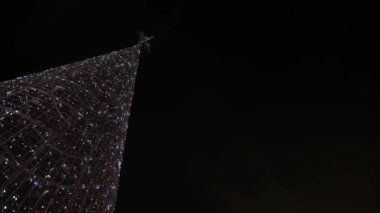 Parlak ışıklandırmalı yüksek metal çerçeve Noel ağacı.