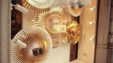 Pahalı bir İtalyan mağazasının vitrininde altın renkli çantalar.