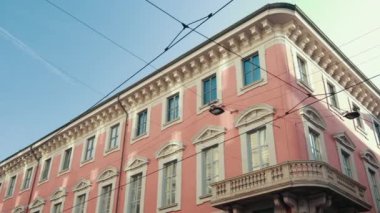 Açık turuncu renkli, balkonlu, güzel mavi gökyüzü olan bir İtalyan evi.