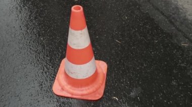 Koyu asfaltta turuncu trafik konileri sıraya dizilmişti. İletişim Kapağını Aç.