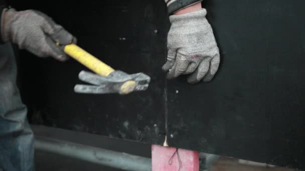 Mans Hand Holding Takes Nail, Hammers, Into Wooden Black Vertical Board, Fence — Stock Video