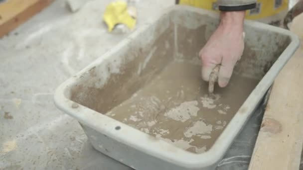 A Mans Hand With Spatula Mixes Liquid Solution In Wheelbarrow For Construction — Stock video