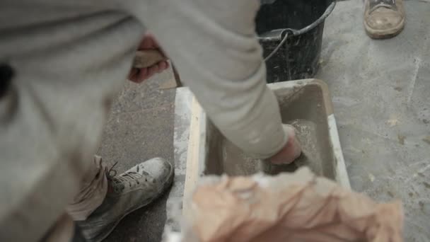 Mão dos homens derrama o pó do cimento no navio com construção líquida da solução — Vídeo de Stock