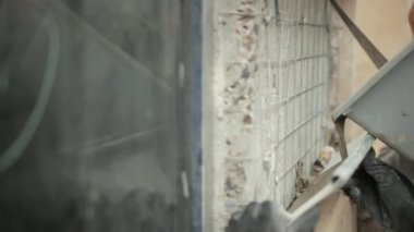 İnşaatçılar, metal bacadan evin duvarındaki deliğe sıvı çözeltisi dökerler.