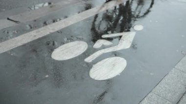 Bisiklet Bir Bisiklet Yolu Boyunca Geçer. Yağmurdan sonra ıslak asfalt. Yol İşaretleri Üzerinde
