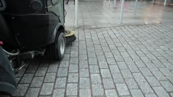 Een veegmachine voor het schoonmaken, wassen van straatstenen gaat naar beneden straat. Langzame beweging. — Stockvideo