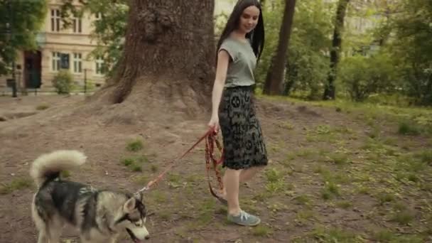 Saf kan Sibiryalı Husky Köpeğiyle Parkta Yürüyen Çekici Sarışın Bir Kadın — Stok video