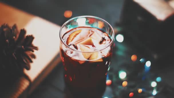 Glühwein im Glas auf schwarzem Holztisch im tollen Hintergrundlicht. Vintage-Farbtöne — Stockvideo