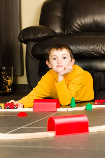 Kid (boy) playing with wooden trains — Stock Photo, Image