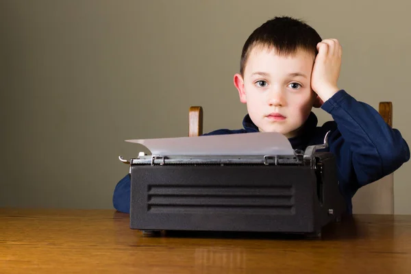 Malý chlapec nepozorný vpředu starých psací stroj — Stock fotografie