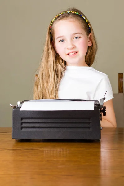 Ragazzina digitando sulla vecchia macchina da scrivere — Foto Stock