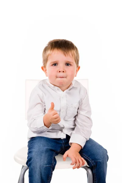 Mały chłopiec siedzi kciuki — Zdjęcie stockowe