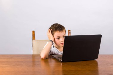 dizüstü bilgisayarda çalışan bir çocuk