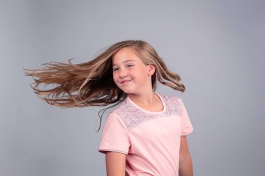 Saçlarını sallayan genç kız.