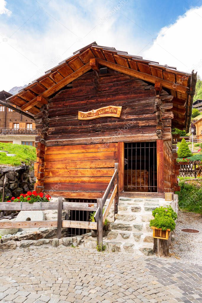 Wooden log cabin of an old water mill (originally constructed 1716) in picturesque swiss alpine village Grimentz, municipality of Anniviers, canton of Valais, Switzerland.