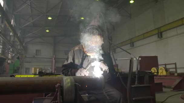 Svetsare i masken svetsar röret genom svetsning i fabriksbutiken — Stockvideo