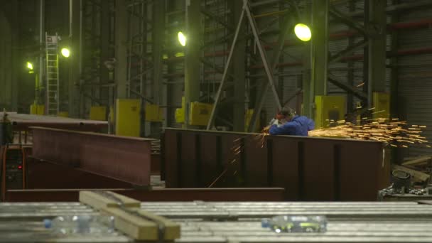 O homem na fábrica serras moedor metal construção — Vídeo de Stock