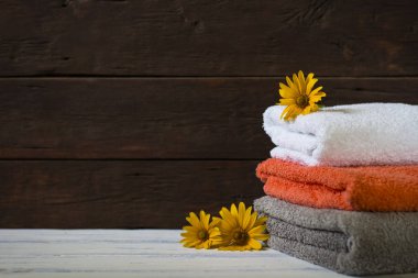 Ahşap arka plan üzerinde farklı renklerde güzel banyo havlusu