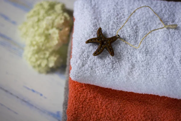 Ahşap bir masa üzerinde farklı renkteki banyo havlusu.