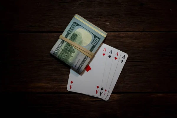 A beautiful image of playing cards and a bundle of money on a wo — Stock Photo, Image