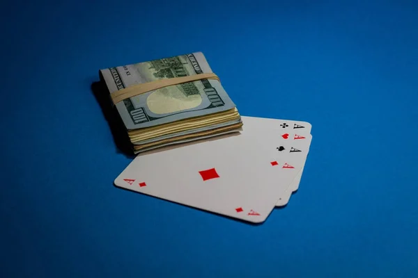 在蓝色的科夫上打牌的顶部有一捆钱的图片 — 图库照片