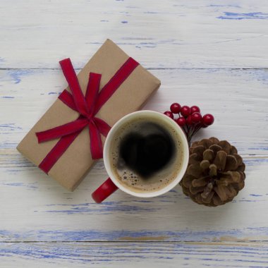 Hediye ile bir kırmızı kurdele, bir fincan kahve ile bir h sargılı