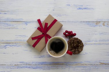 Bir fincan kahve, bir yumru, bir kartopu, kraft pap sarılmış bir hediye