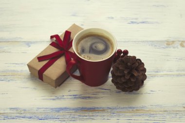 Bir bardak taze demlenmiş kahve, bir çam kozalağı, bir kartopu, bir GIF