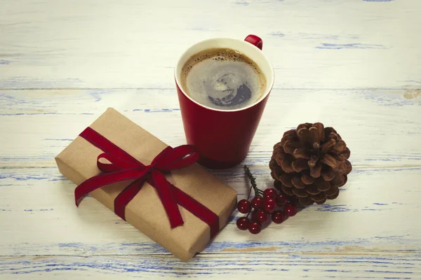 Red coffee cup, gift, fir cone, decorative viburnum — Stock Photo, Image